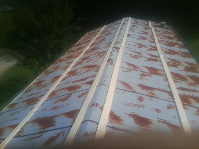 Rusted metal roof panels with new wood purlins before replacement — Storm Damage Roof Repair in Hampton by Roofing Brothers